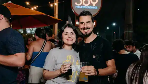 Público animado no evento INjoy da Joy Project Brewing, com pessoas sorrindo e brindando com chope artesanal